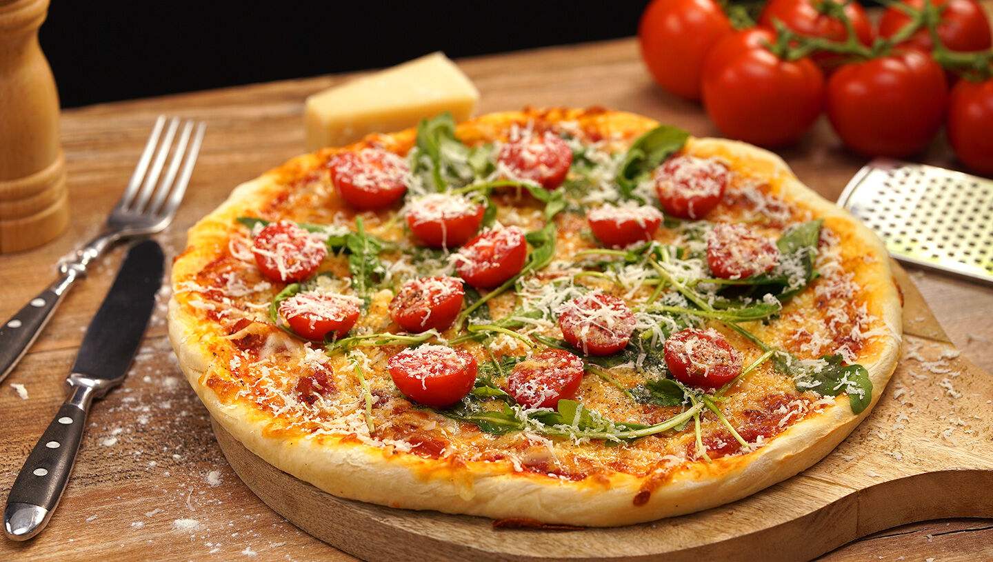 Selbstgemachte Pizza mit Rucola und Tomaten | ORO di Parma