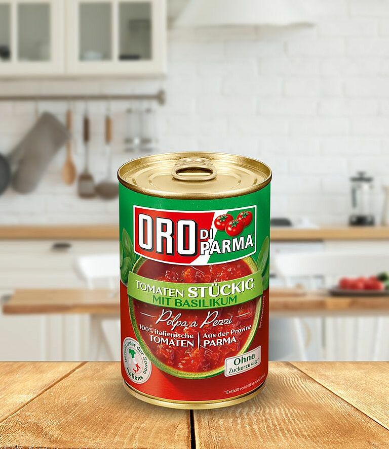 Eine Dose ORO di Parma stückige Tomaten mit Basilikum steht auf einem Holztisch