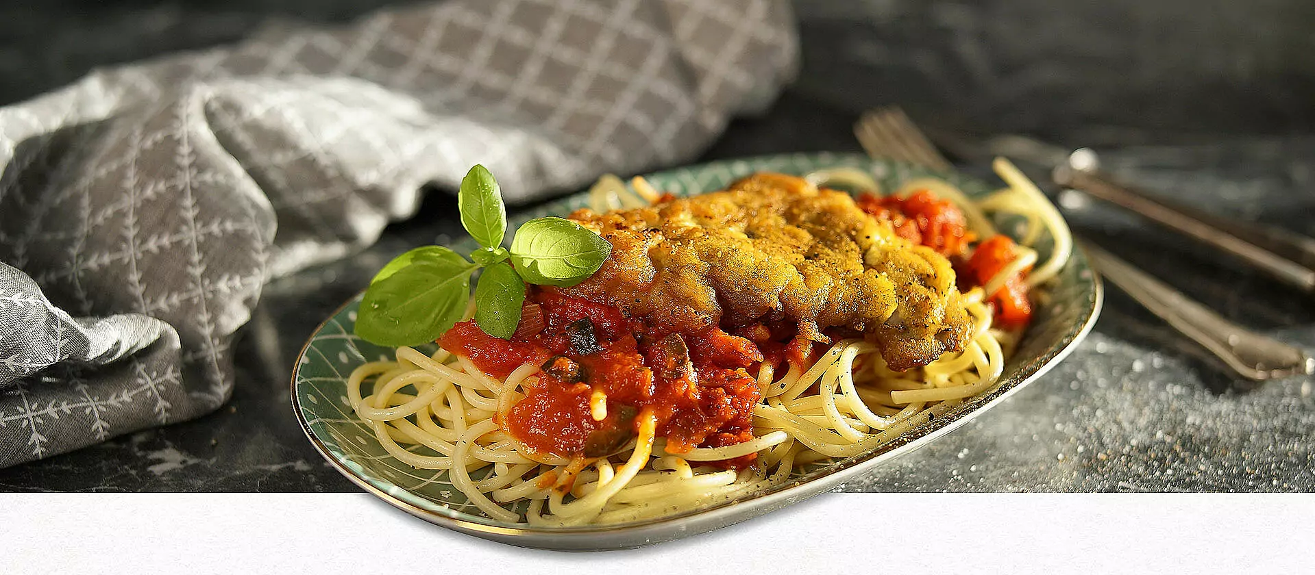 Ein Teller mit Pasta, Sauce und Schnitzel Mailänder Art